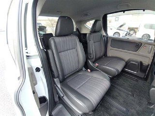 Средний ряд и задние сиденья Honda Freed 2018: складные кресла, свободное пространство для пассажиров и состояние обивки видно с ракурса открытой двери.