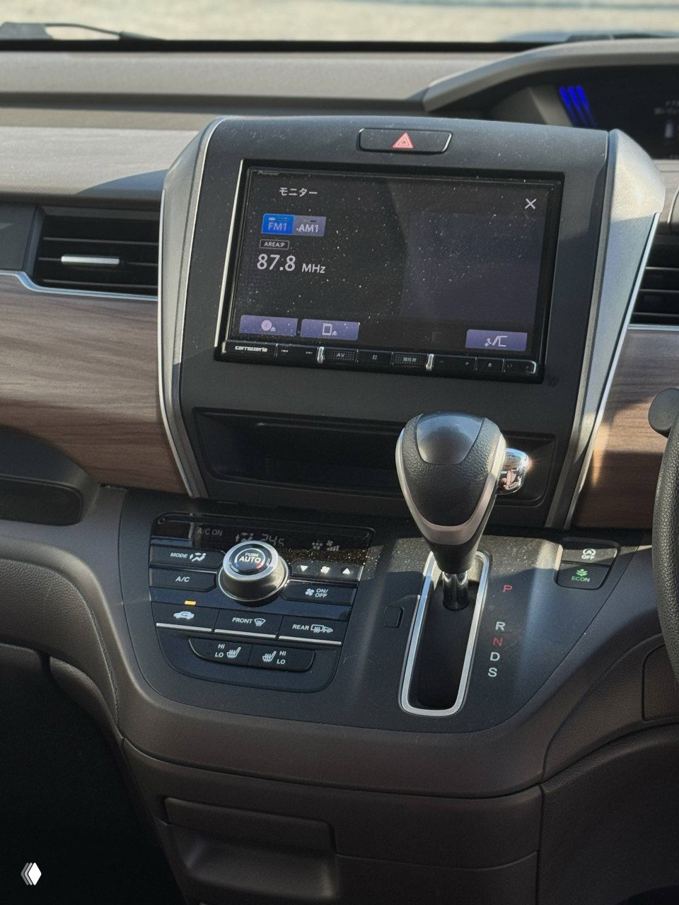 Центральная консоль и селектор коробки передач Honda Freed 2021, мультимедиа-экран и блок управления климатом показаны близко.