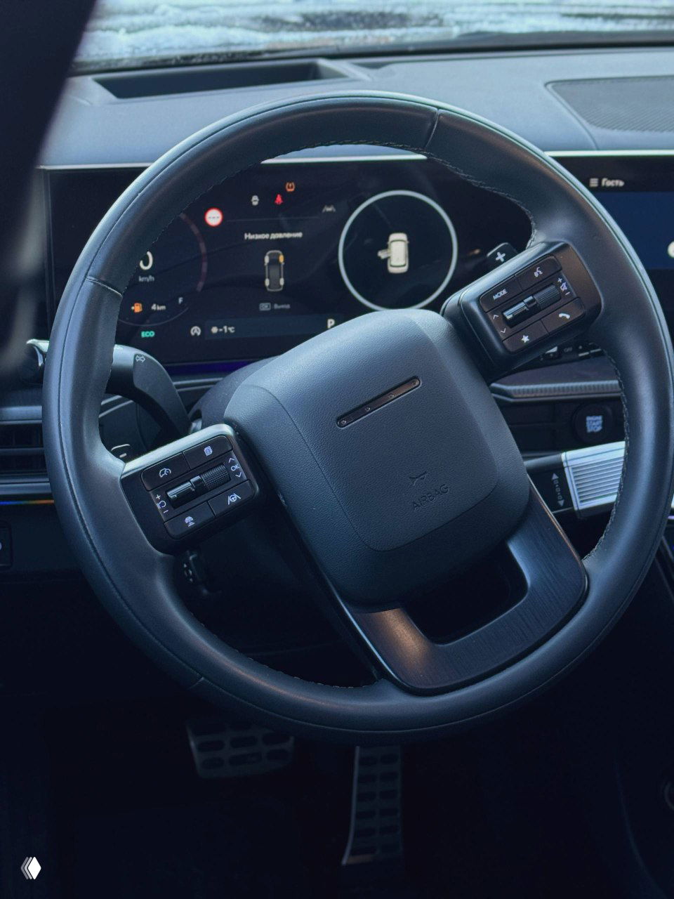 Рулевое колесо и приборная панель Hyundai Santa Fe нового поколения — крупный план руля, элементы управления на спицах и цифровая комбинация приборов на фоне.