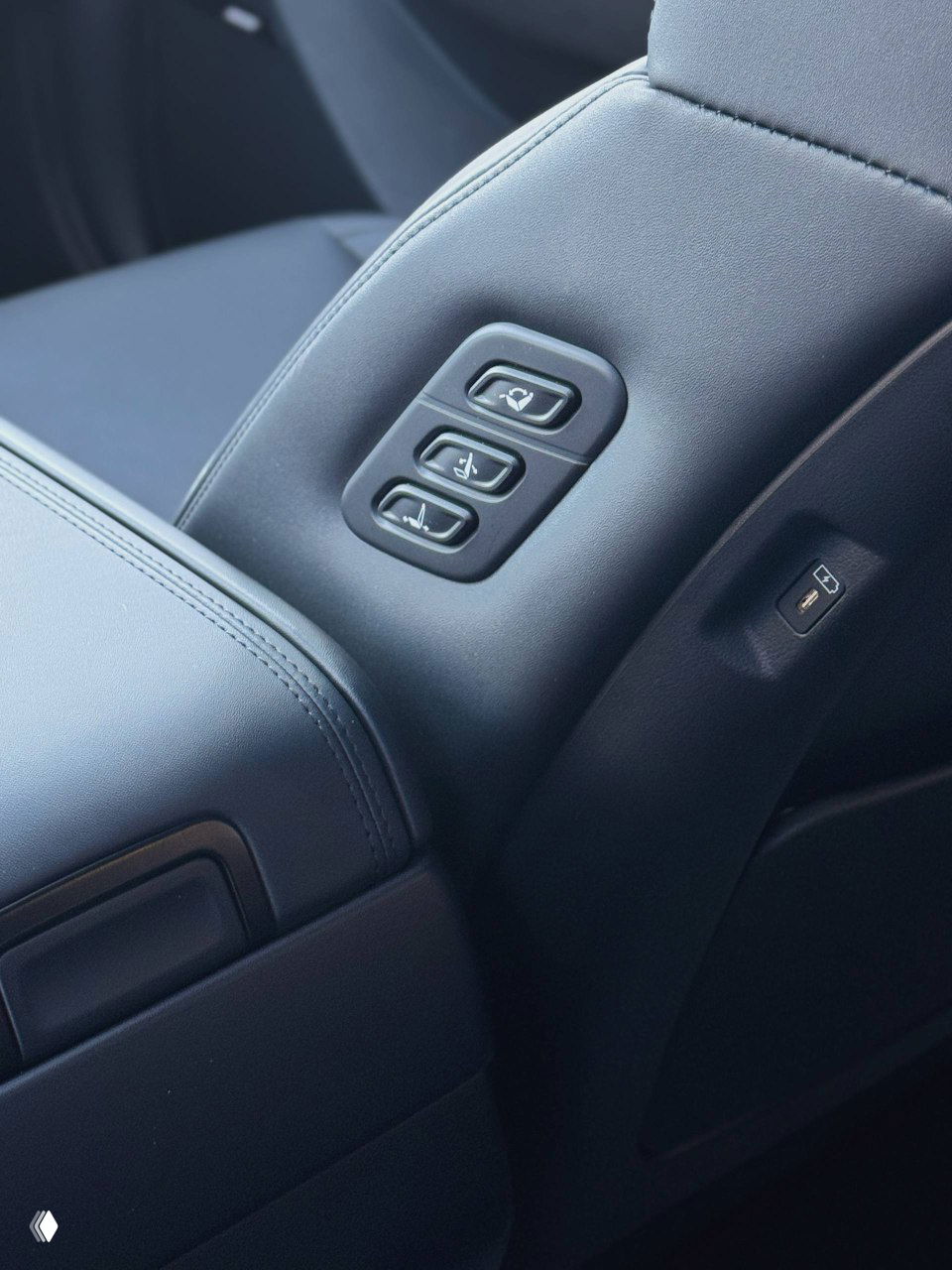 Регулировки сидений и панели управления на боковой части центрального подлокотника для задних пассажиров, крупный план кнопок памяти и регулировок.