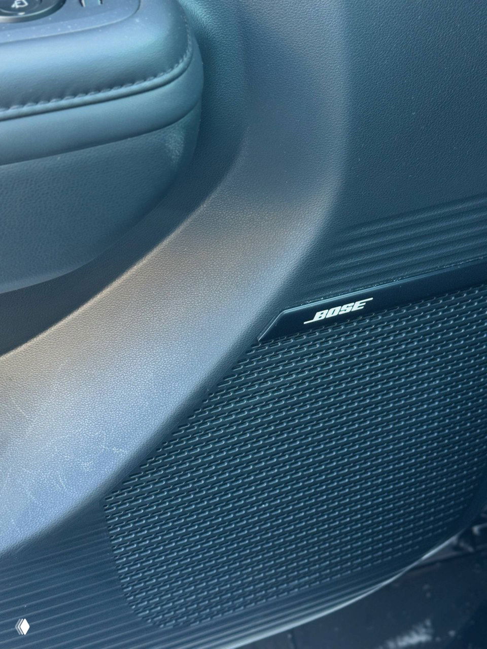 Динамик Bose в дверной панели Hyundai Santa Fe — крупный план акустического корпуса с логотипом BOSE в интерьере автомобиля.