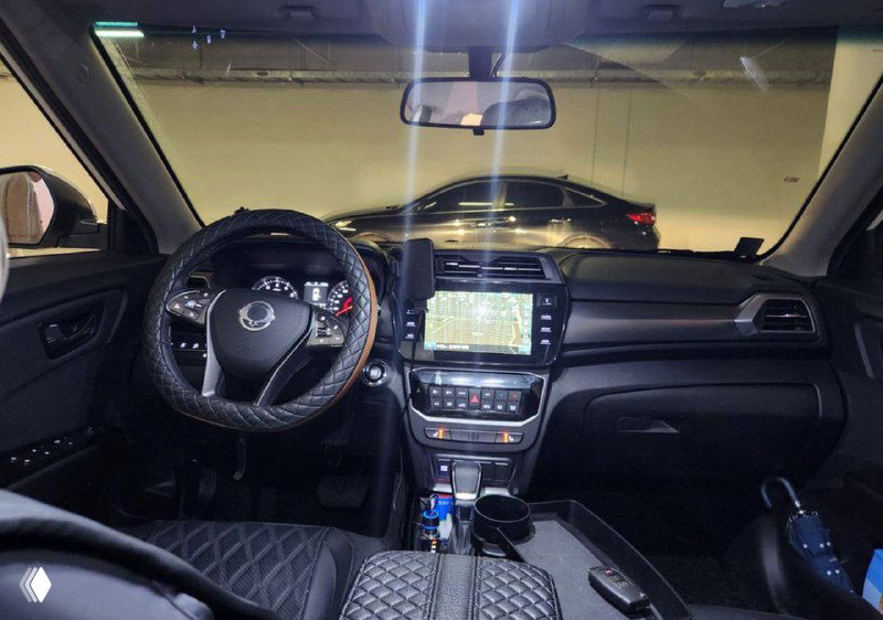 Интерьер SsangYong Tivoli: панель управления, мультимедийный экран и руль; фото салона автомобиля на стоянке для оценки состояния.