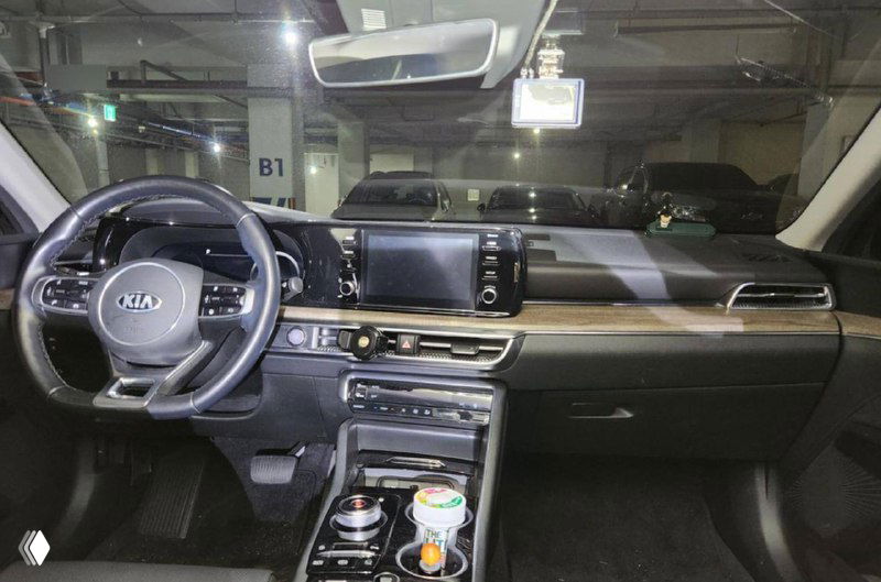 Салон KIA K5: передние сиденья, мультимедийный экран и центральная консоль; фото для оценки состояния интерьера перед покупкой.