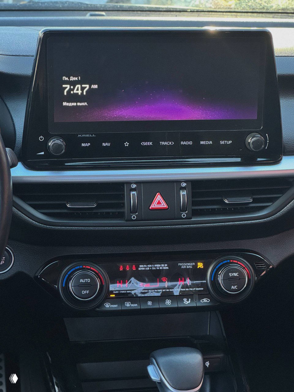 Панель мультимедиа KIA K3: крупный сенсорный дисплей и блок управления климатом с подсветкой, видна консоль центральной панели.