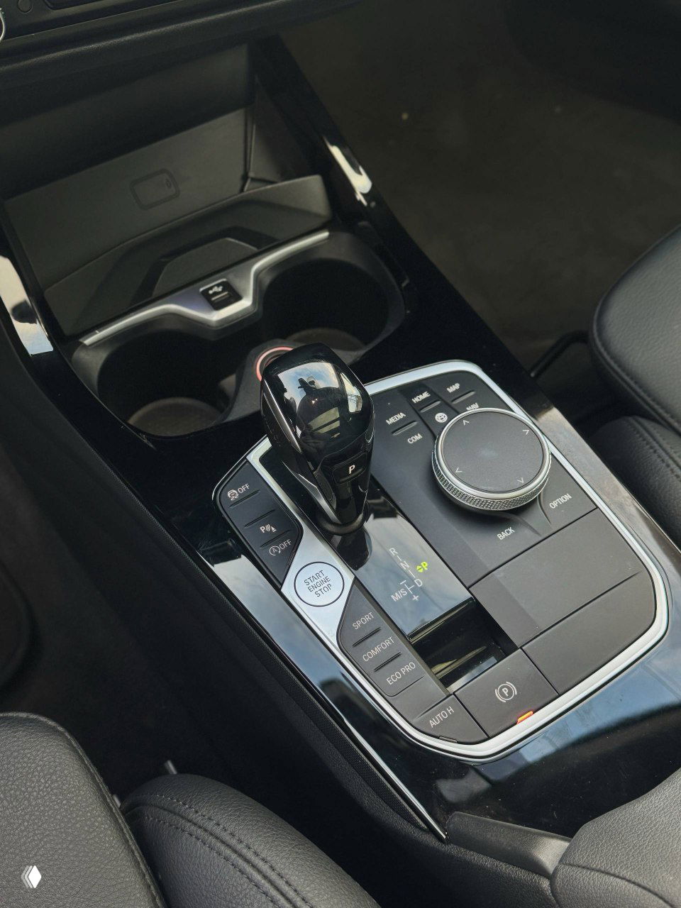 Центральная консоль BMW 220i: селектор передач, регулятор iDrive, кнопки режимов движения и глянцевая отделка между передними сиденьями.