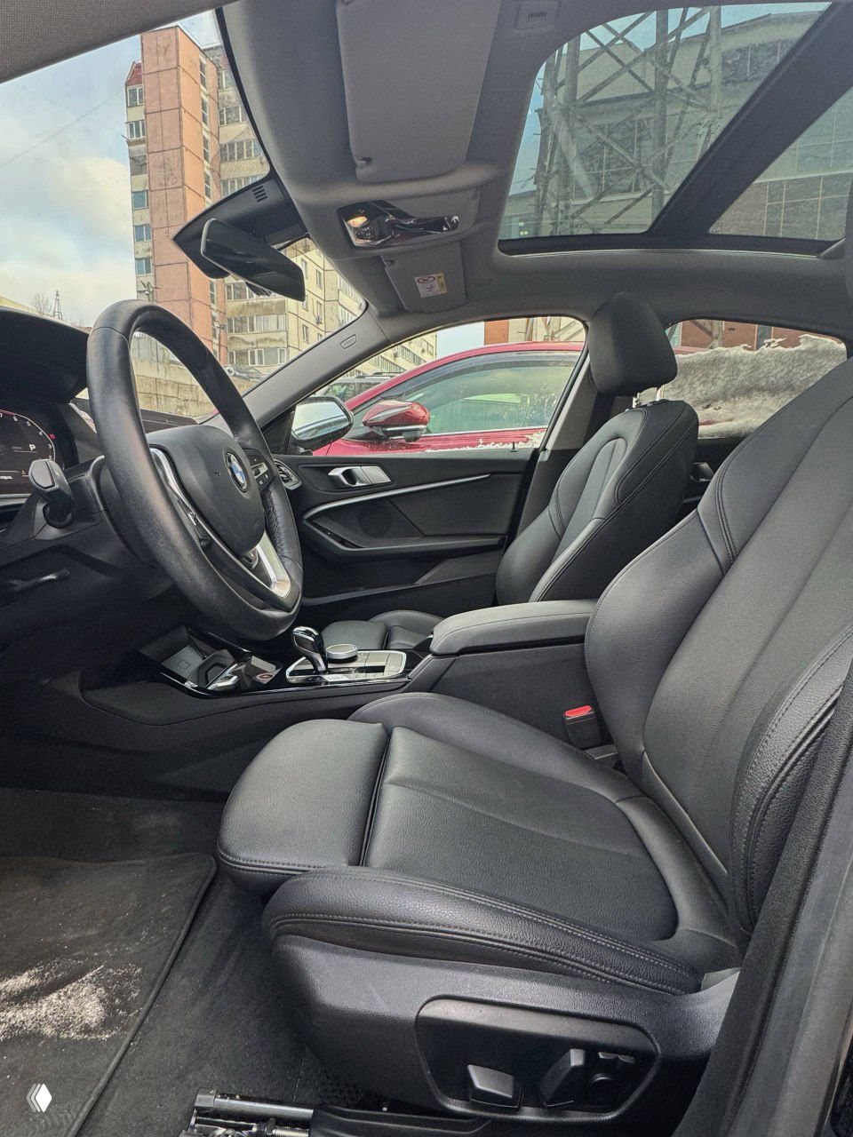Передние сиденья BMW 220i в кожаной отделке, панорамная крыша и общий вид салона со стороны пассажирского сиденья, чистое состояние интерьера.