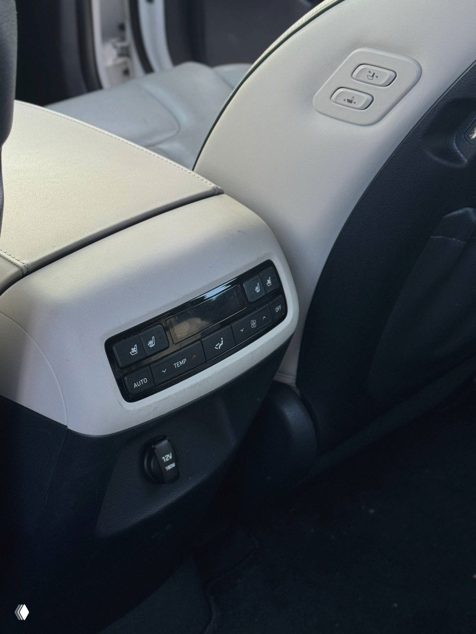 Панель управления климатом для задних пассажиров и розетка 12V в Hyundai Palisade; видны регуляторы температуры и элементы управления дополнительного комфорта.