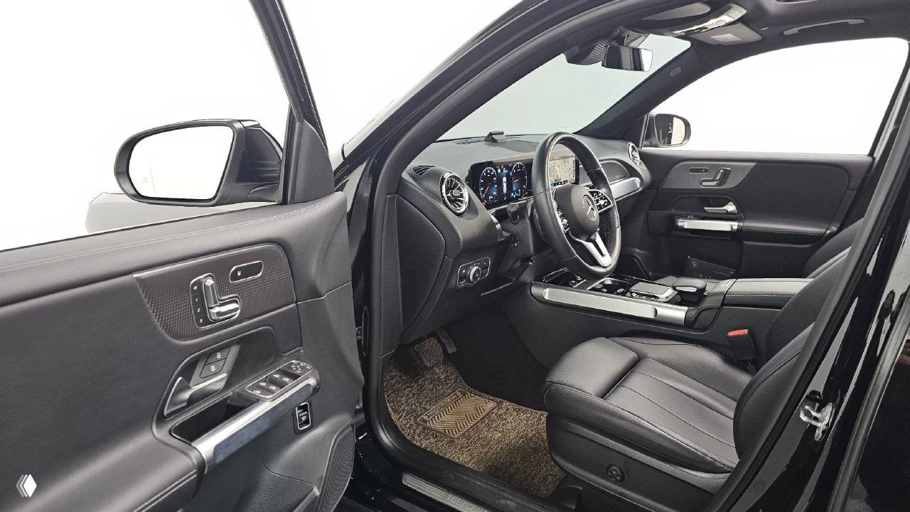 Открытая водительская дверь и вид на переднее сиденье Mercedes GLB200d, панель управления дверью с регулировками сидений и отделкой, фото салона.