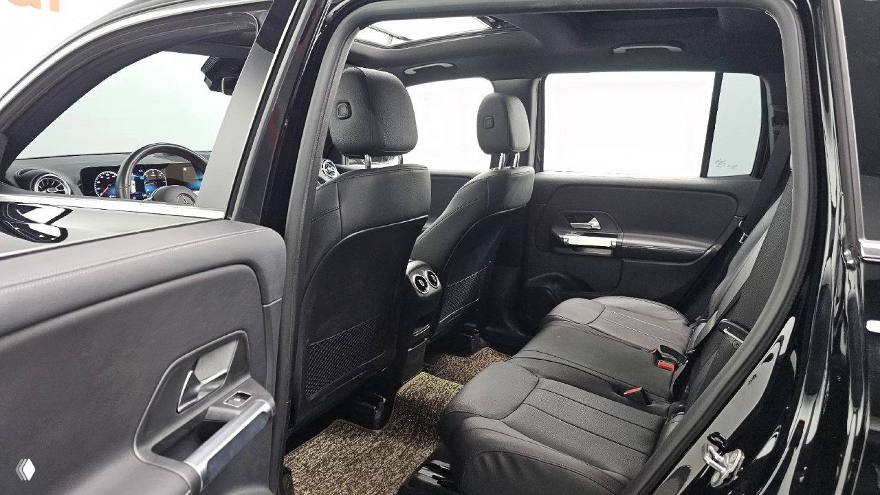 Задний ряд сидений Mercedes GLB200d: трёхместный диван, состояние обивки, напольные коврики и пространство для пассажиров на заднем сиденье.