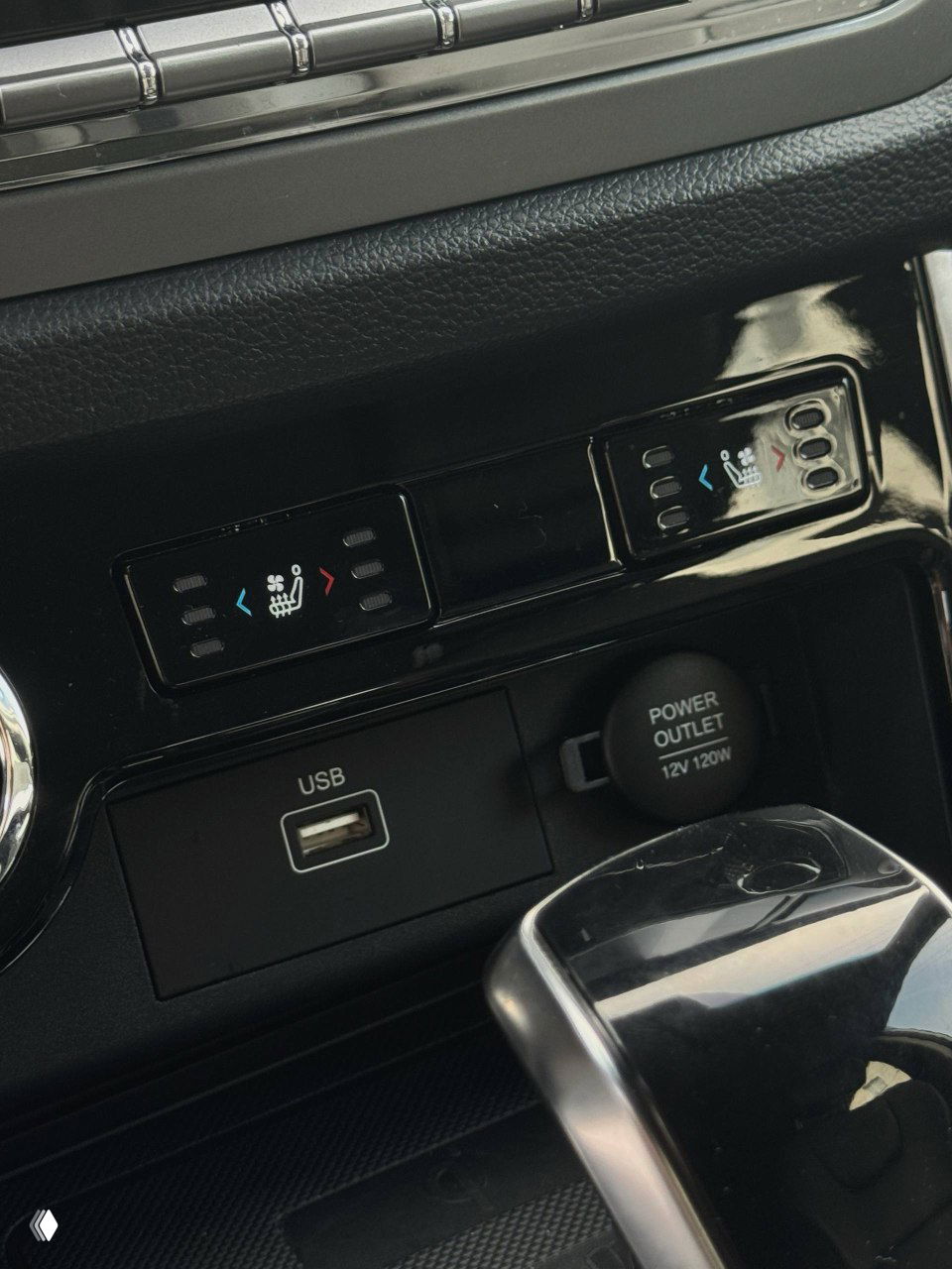 Разъёмы USB и 12V power outlet рядом с кнопками управления подогревом сидений и другими функциями в центральной части салона Korando.