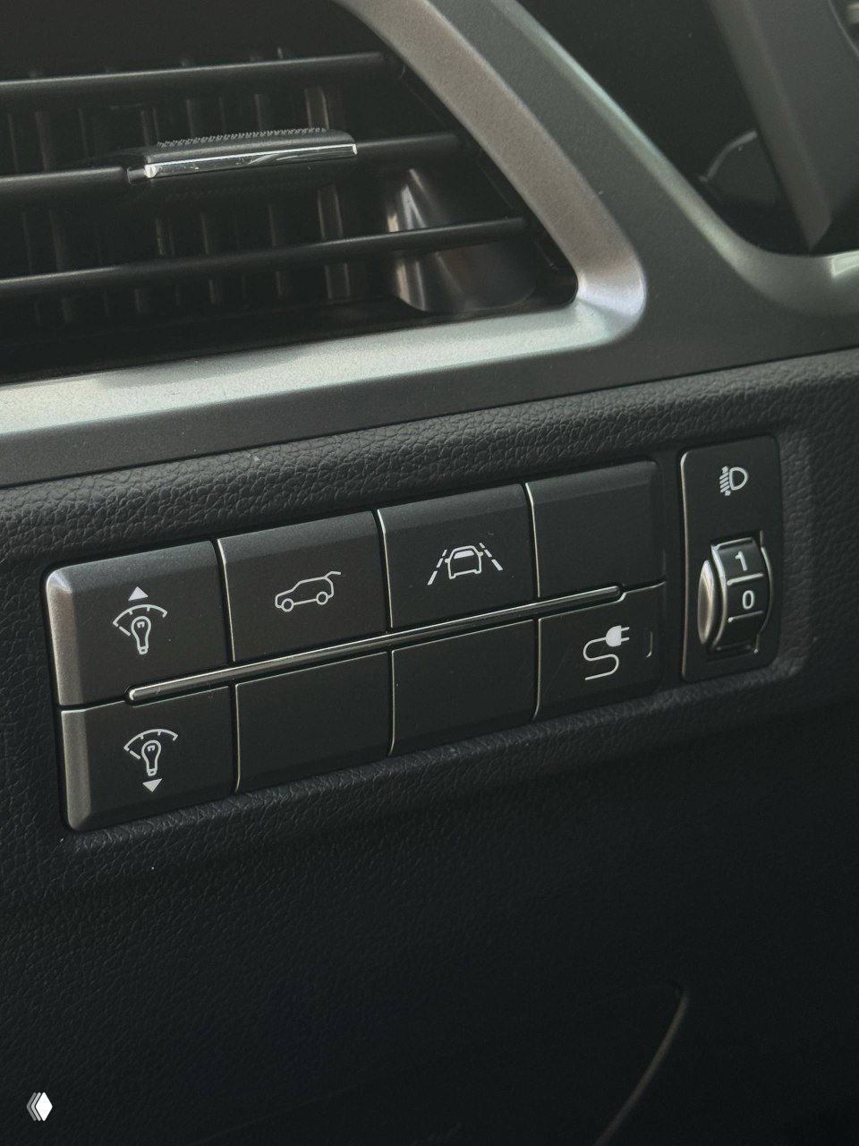 Панель с кнопками ассистентов водителя и регулировкой света в салоне SsangYong Korando — кнопки парковки, система удержания полосы и регулировка фар.