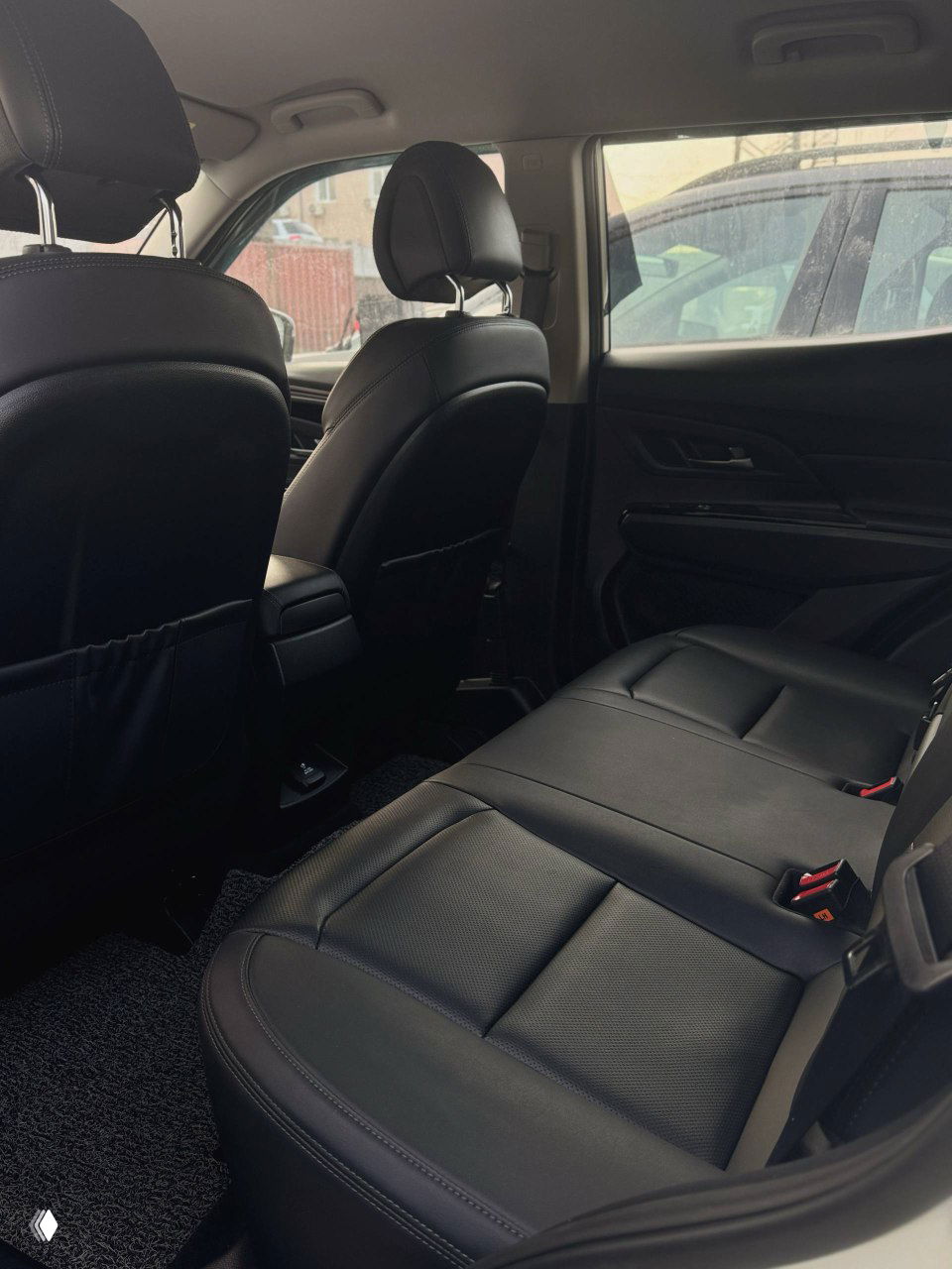 Задний ряд сидений SsangYong Korando с чёрной кожаной обивкой — вид на пространство для пассажиров и дверные панели, чистое состояние салона.
