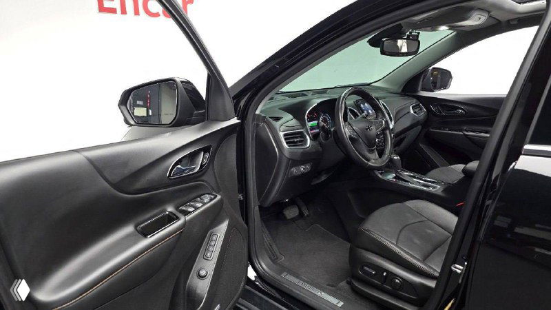 Открытая передняя дверь и вид на переднее сиденье и панель с угла — демонстрация состояния обивок и пространства в салоне.