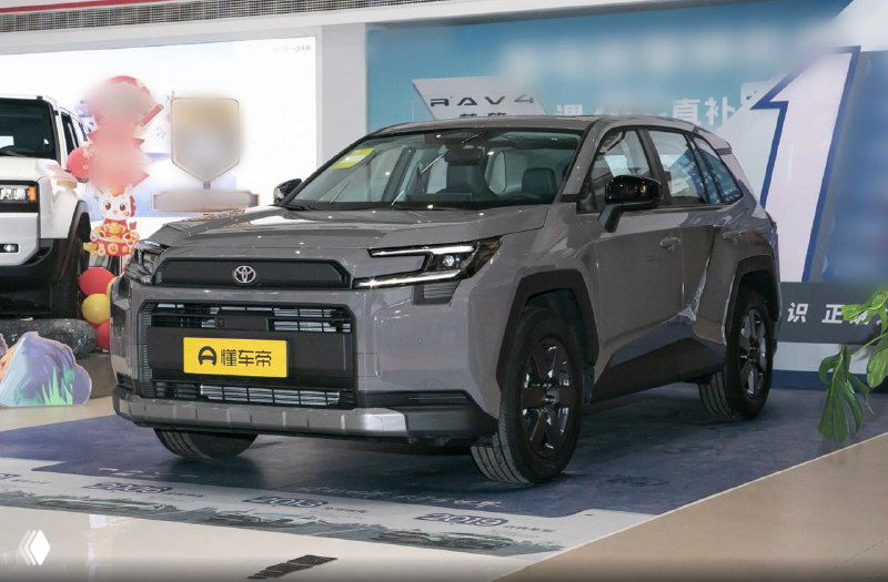 Toyota RAV4 2026 серо‑коричневого оттенка в выставочном зале; фото подчёркивает лакокрасочное покрытие и фронтальную часть модели