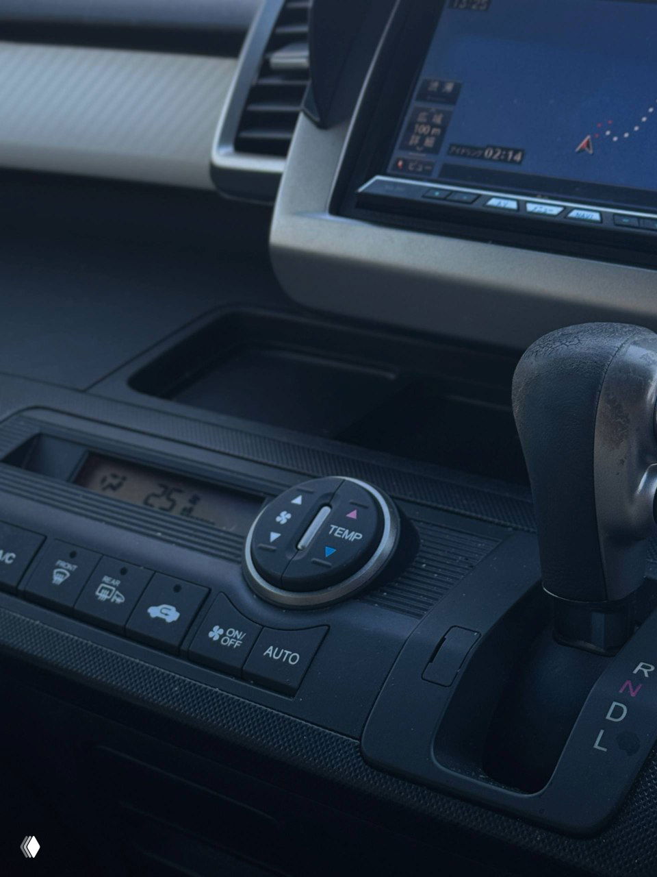 Передняя консоль и селектор передач Honda Freed, блок климата с кнопками AUTO и регулятором температуры, вид рабочего пространства водителя.