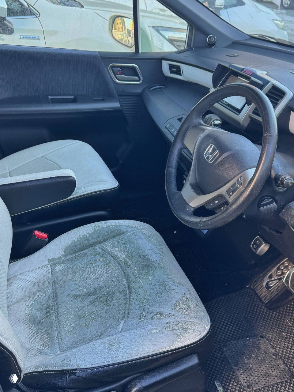 Переднее пассажирское сиденье и водительская зона Honda Freed с видом на сиденья, состояние обивки и общая планировка салона.