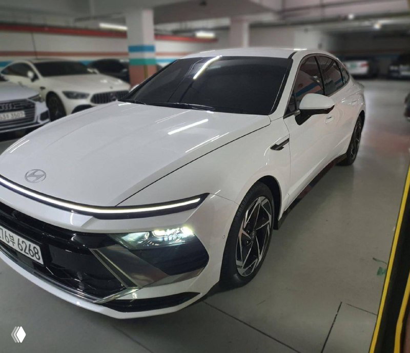 Общий вид под углом: белый Hyundai Sonata 2025, боковая часть и передняя колесная зона — демонстрация дисков и наружного дизайна кузова.