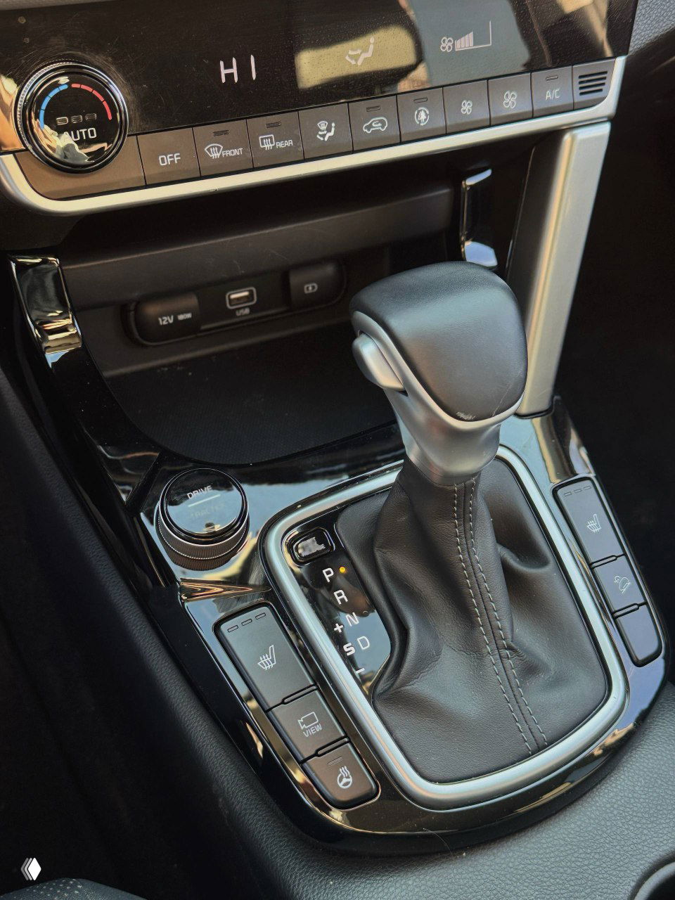 Рычаг переключения передач и кнопки управления обогревом сидений на центральной консоли KIA Seltos, интерьер вблизи