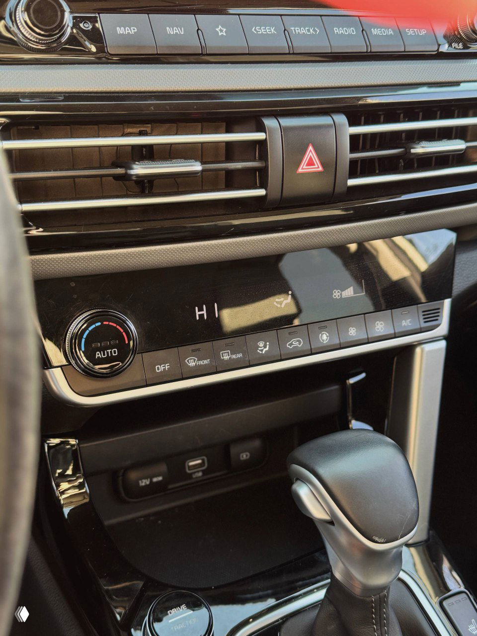 Крупный план центральной панели с климат-контролем, вентиляционными решётками и кнопками, аккуратный салон KIA Seltos