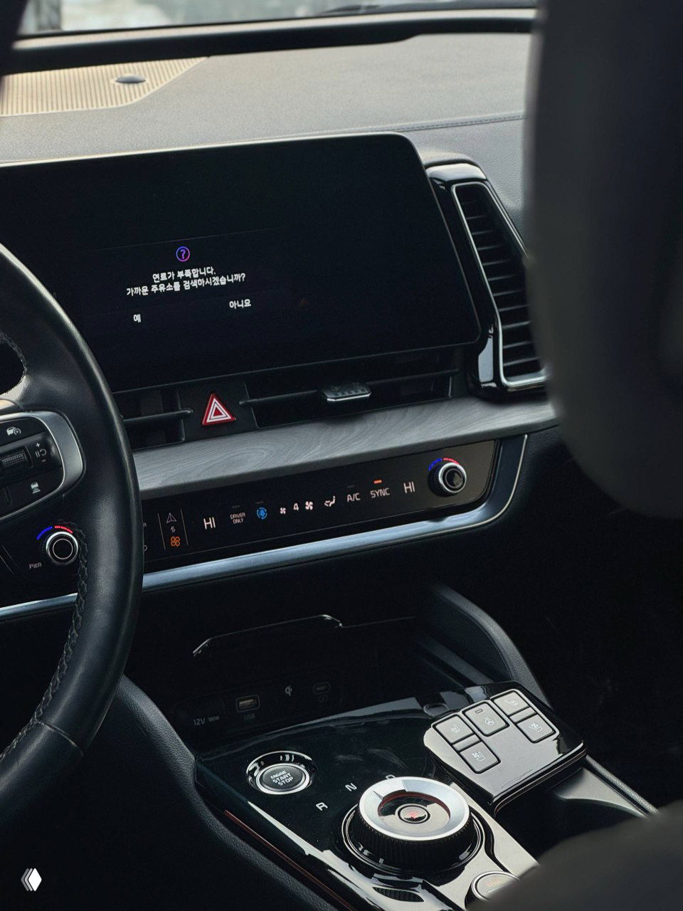 Салон KIA Sportage: центральная консоль с большим сенсорным экраном, элементы климат-контроля и шайба переключения передач, чистая заводская отделка.