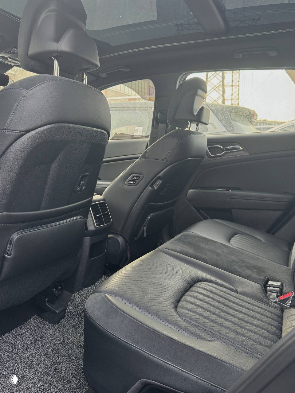 Задний ряд сидений KIA Sportage 2023: чёрная обивка, вид на пространство для пассажиров и качество отделки, салон без явных следов эксплуатации.
