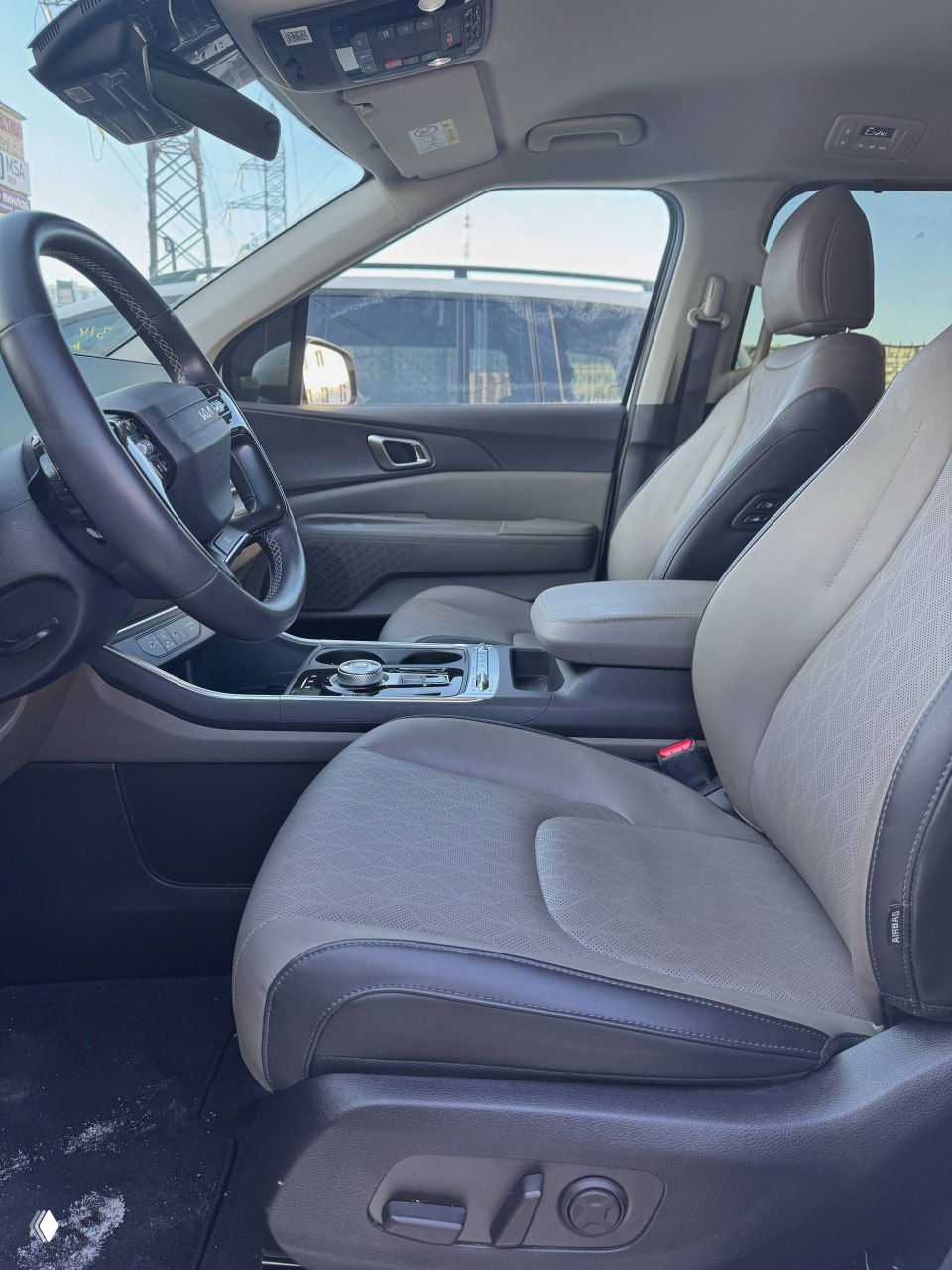 Водительское сиденье и передняя панель KIA Carnival, вид на кресло, дверную карту и центральную консоль со стороны пассажира.