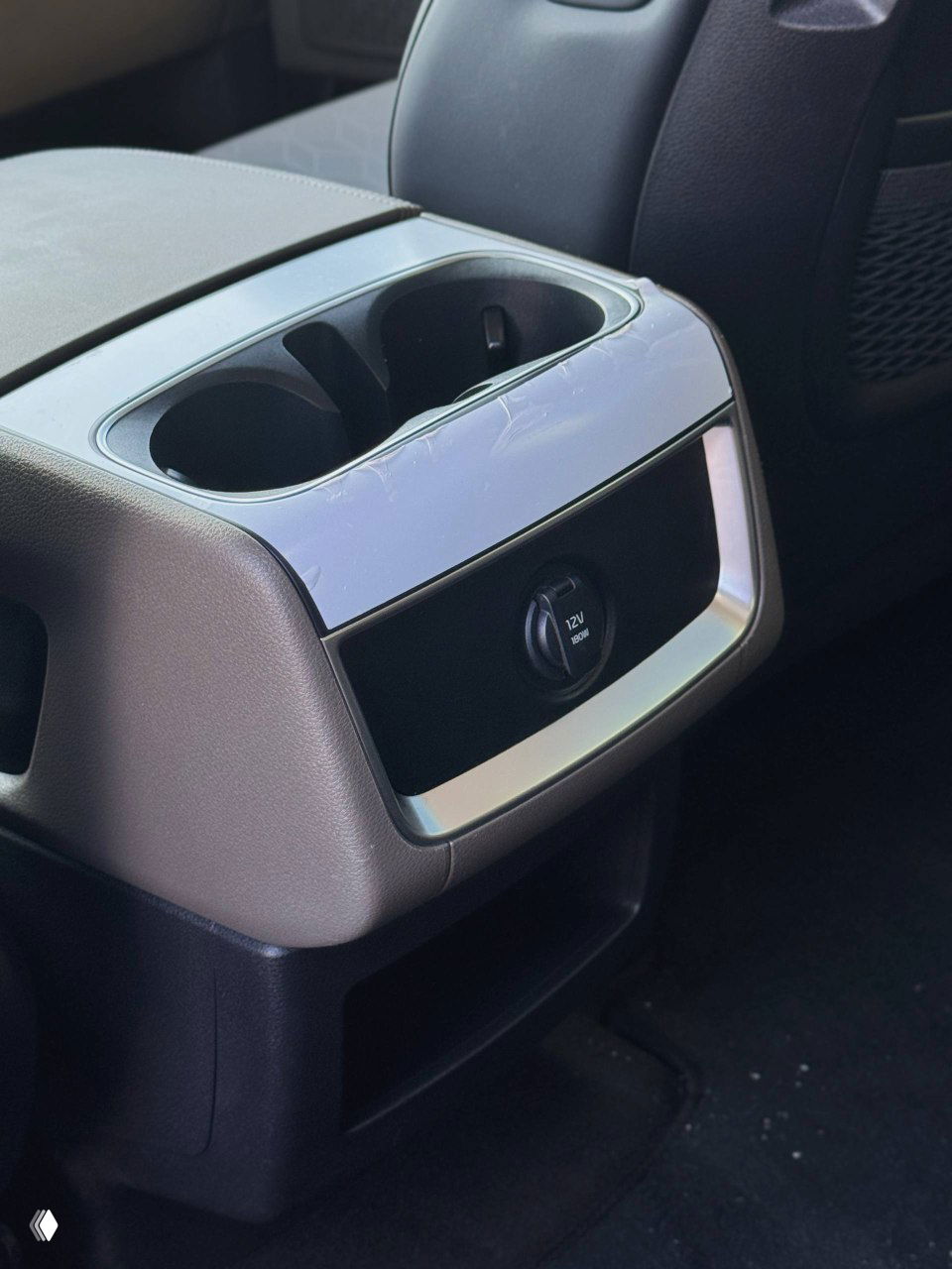 Нижняя часть центрального консольного блока: подстаканники и розетка 12V для задних пассажиров, вид на отделение хранения.