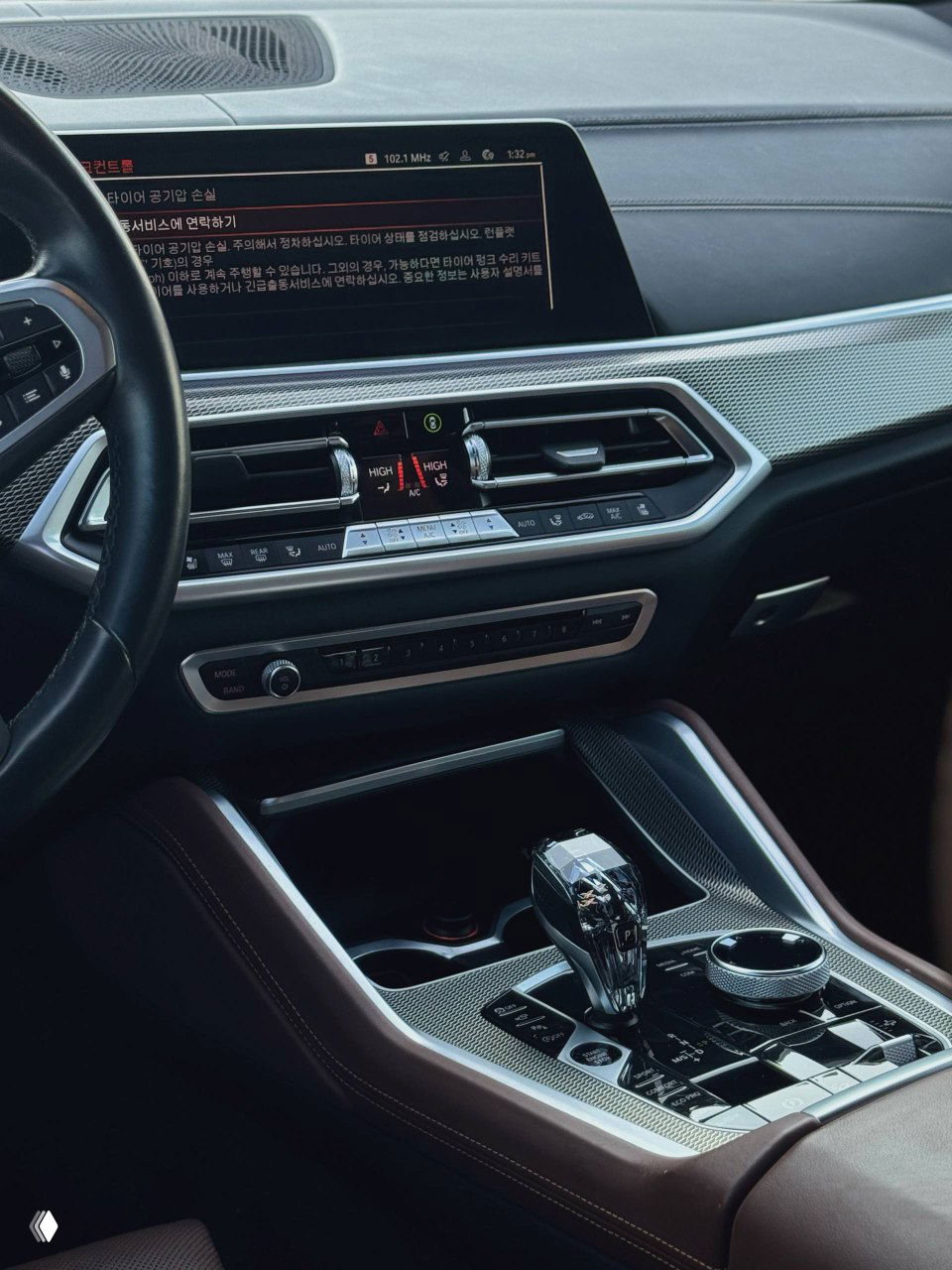 Интерьер приборной панели и мультимедиа BMW X6: большой экран, вентиляционные решётки и элементы управления климатом, акцент на отделке.