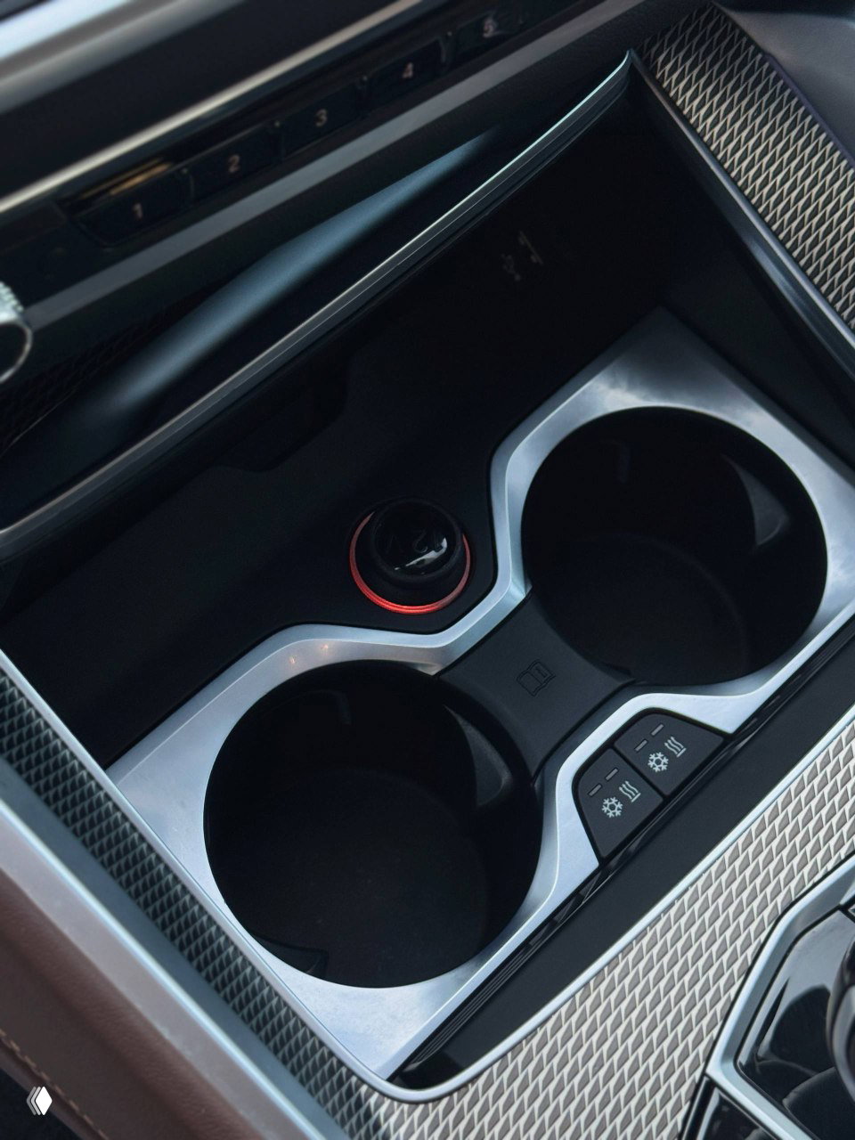 Крупный план подстаканников и центральной консоли BMW X6 с хромированной окантовкой и кнопками подогрева/управления аксессуарами.