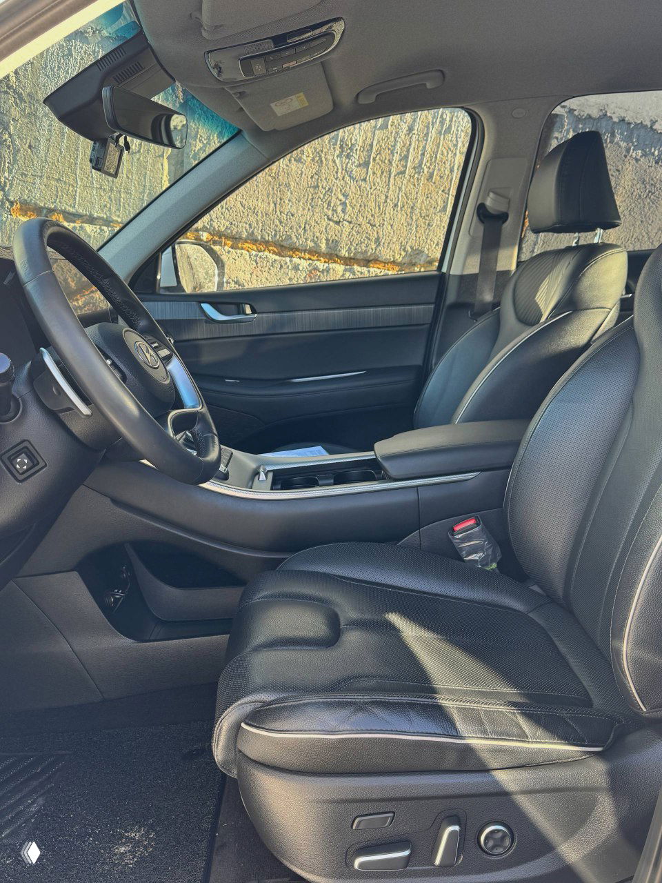 Переднее пассажирское и водительское кресла Hyundai Palisade с чёрной отделкой, видно состояние кожи и регулировки сиденья