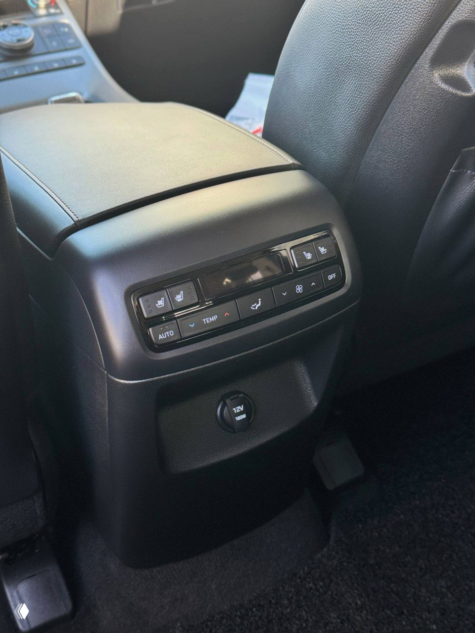 Панель управления климатом и розетка 12V в задней части туннеля между передними сиденьями Hyundai Palisade, видны кнопки управления