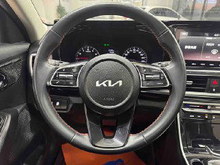 Рулевое колесо KIA KX3 с логотипом Kia, элементы управления на руле и приборная панель в зоне водителя; снимок салона для покупателя.