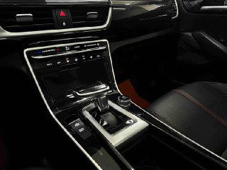 Центральная консоль и селектор коробки вариатора KIA KX3 2022, вид на мультимедийную панель и элементы управления климатом в салоне.