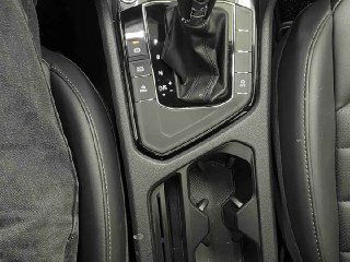 Крупный план селектора роботизированной коробки передач и подстаканников в салоне Volkswagen Tharu; вид материалов отделки.