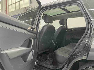 Фотография задних сидений Volkswagen Tharu: пространство для ног, обивка сидений и общий вид второго ряда в дилерском зале.