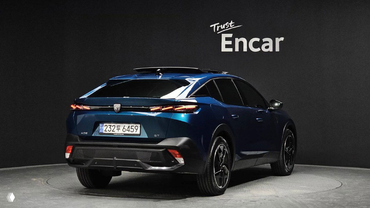 Peugeot 408 сзади под углом на студийной платформе, видна задняя оптика и номерная рамка Южной Кореи, общий вид для оценки состояния кузова.