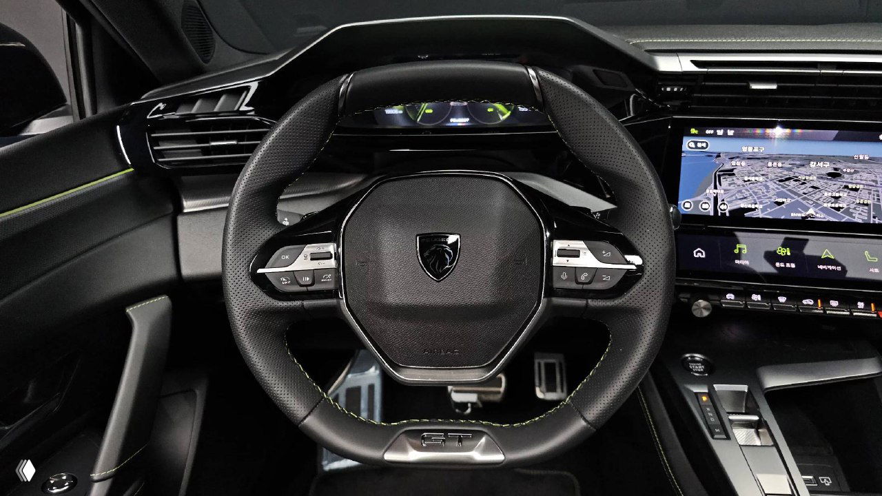 Руль Peugeot 408 крупным планом, мультируль с логотипом, кнопки управления и отделка, видно спортивный дизайн и строчку на коже.