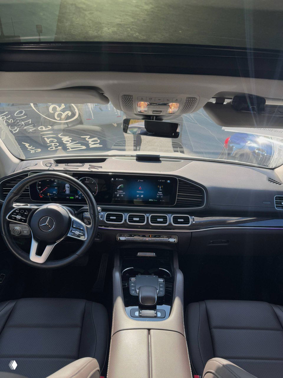 Панорамный вид салона Mercedes GLE300d: передняя панель, руль, большой дисплей приборной панели и панорамный люк для оценки комплектации при импорте.