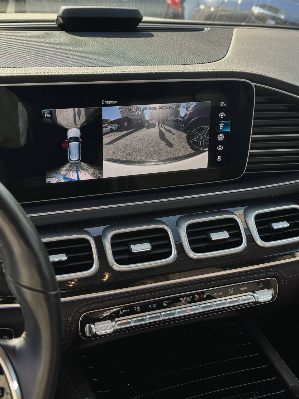 Дисплей мультимедиа Mercedes GLE300d с показом изображения камеры и меню на экране над воздуховодами передней панели для демонстрации функционала.