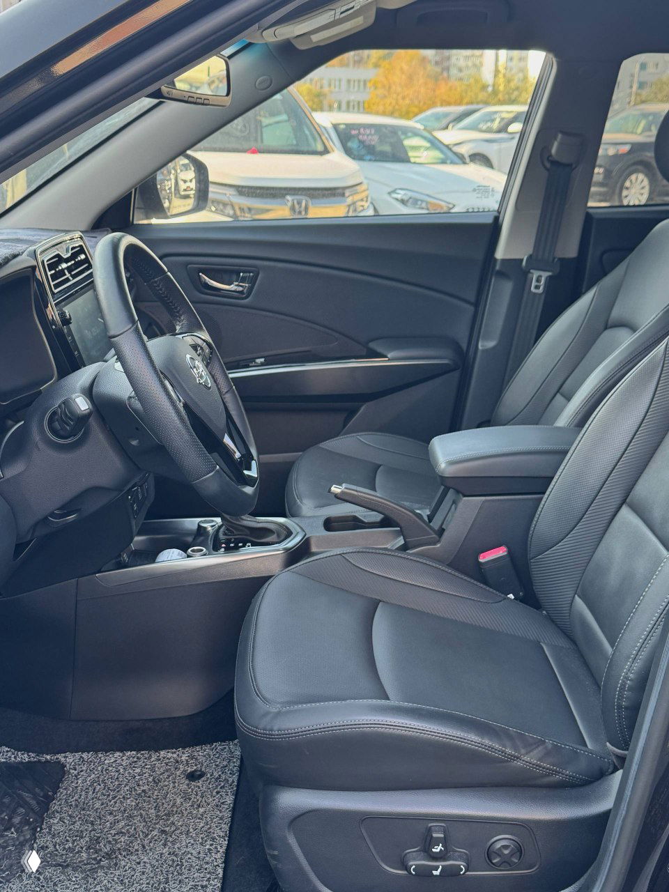 Передние сиденья SsangYong Tivoli в чёрной кожзаменительной обивке, видны регулировки и центральный подлокотник, состояние без сильного износа.