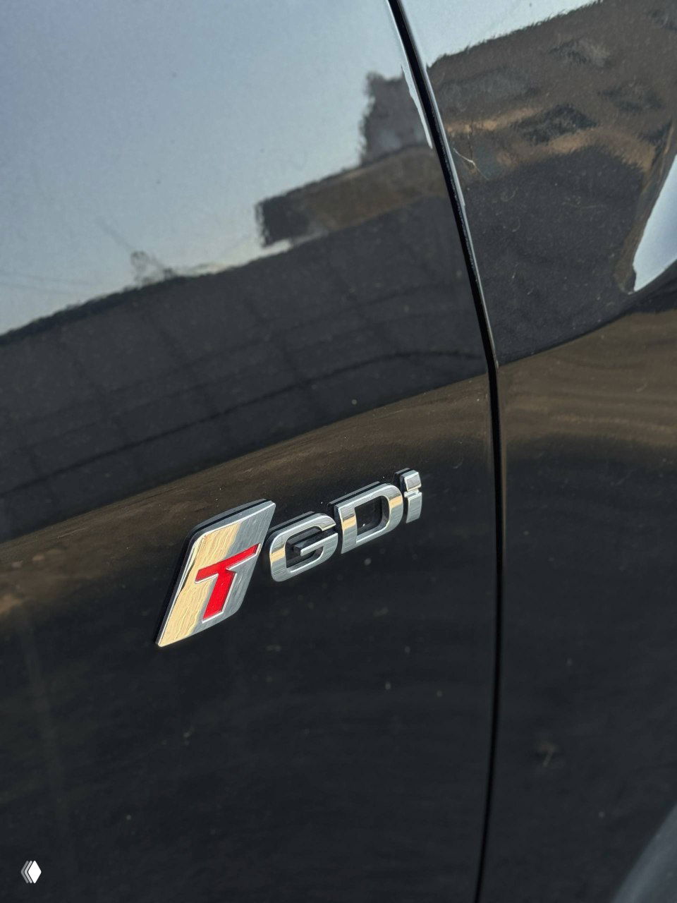 Крупный план шильдика T-GDI на боковой двери SsangYong Tivoli — маркировка, указывающая на тип двигателя и технологию турбонаддува.