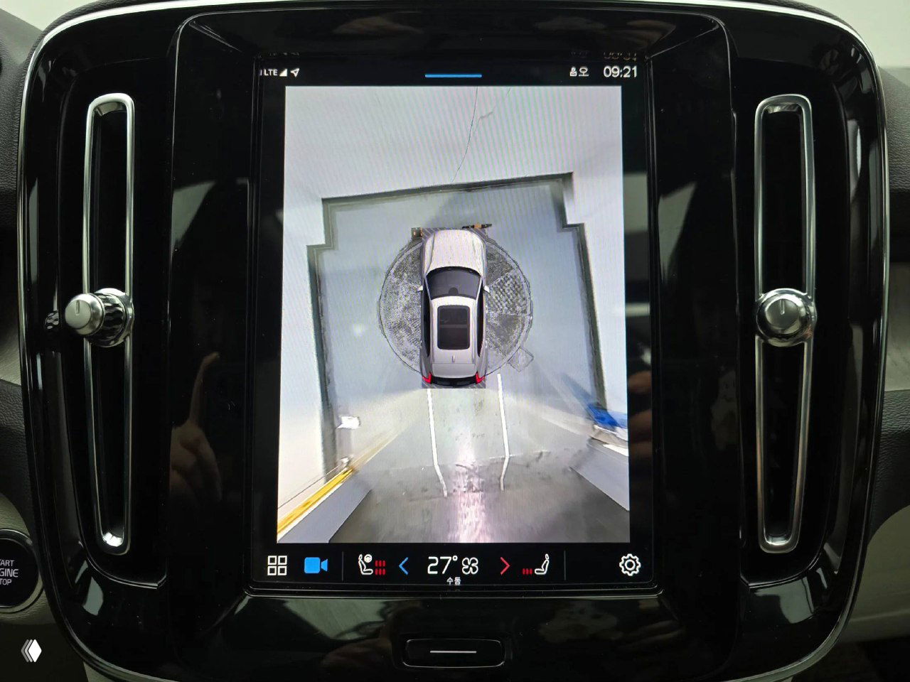 Центральный экран мультимедиа Volvo XC40 отображает панорамный вид сверху — камера обзора 360°, крупный план сенсорного дисплея