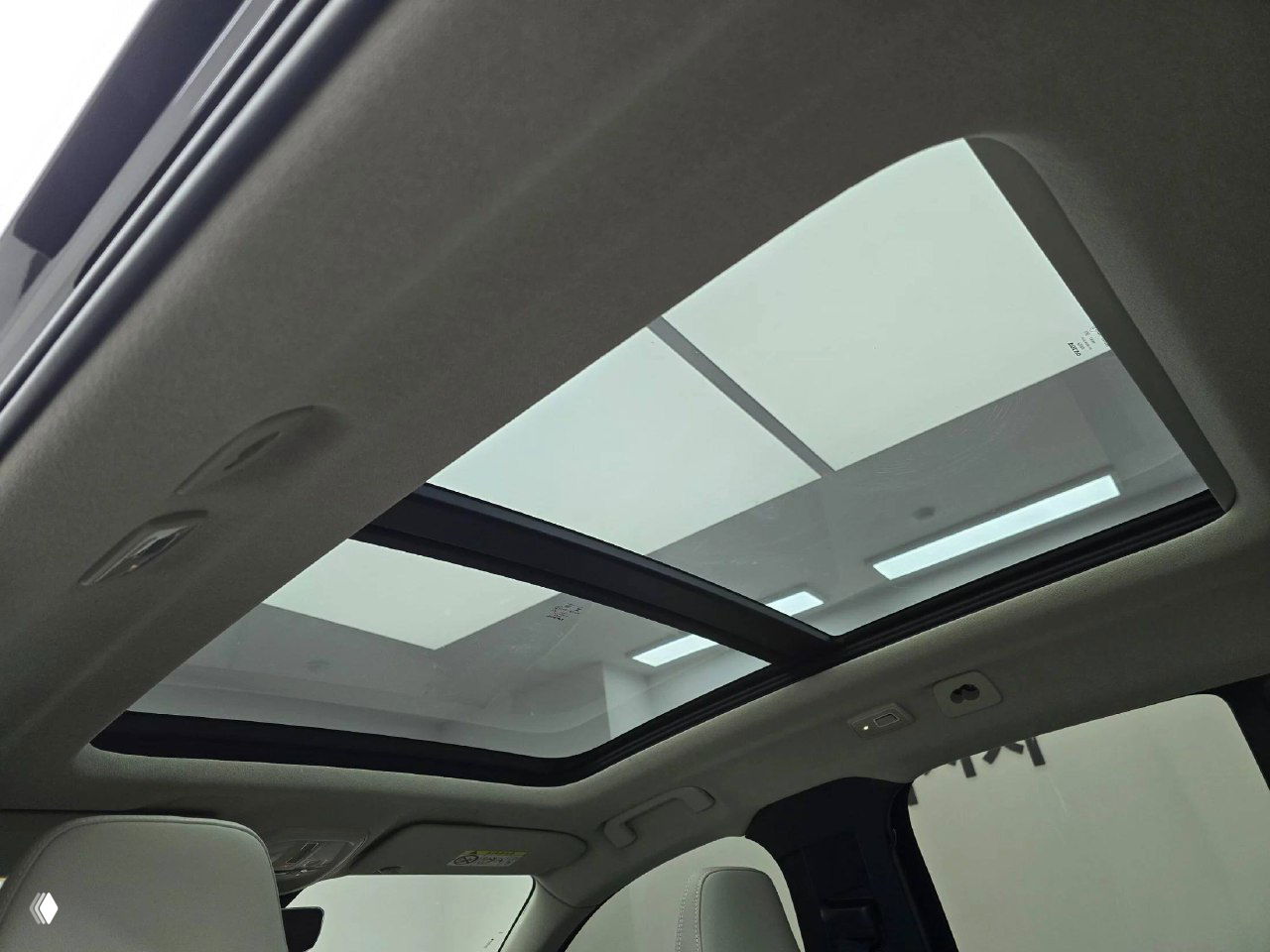 Панорамная крыша Volvo XC40 крупным планом — стеклянный люк, вид изнутри на верхнюю часть салона и рамку люка