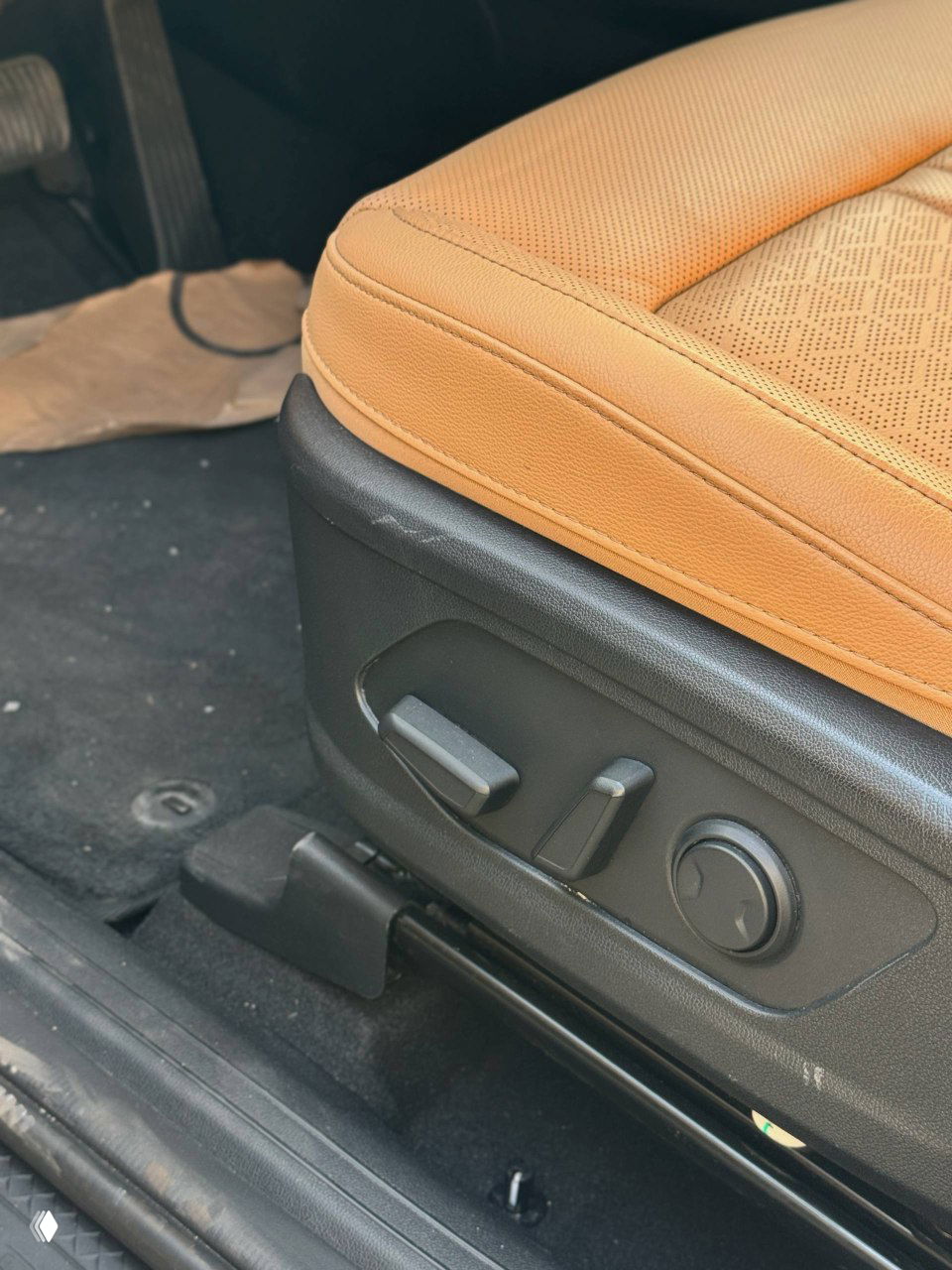 Крупный план регулировок и боковой части переднего сиденья KIA Sorento: электрические регуляторы, состояние обивки и направляющие механизма в деталях.