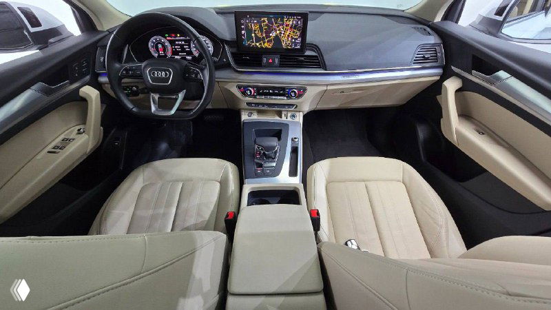 Интерьер Audi Q5 Sportback: передние сиденья бежевой обивки, центральный тоннель и мультимедийный экран, вид сзади на салон и отделку.