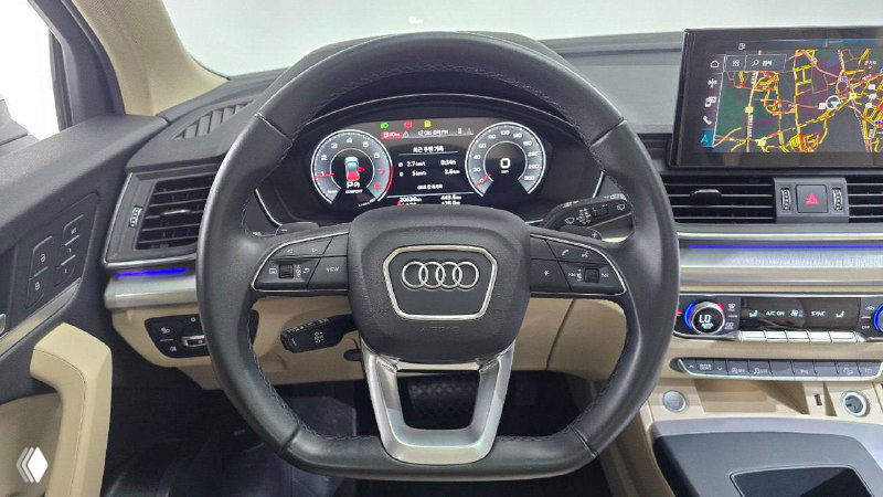 Руль Audi с логотипом, цифровая приборная панель и органы управления — крупный план водительского места и сочетание приборов в 2023 модели.