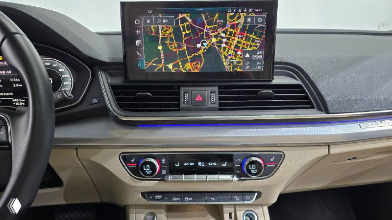 Центральная консоль Audi Q5 Sportback с выдвижным дисплеем мультимедиа, навигационной картой и блоком климата — крупный план элементов управления.