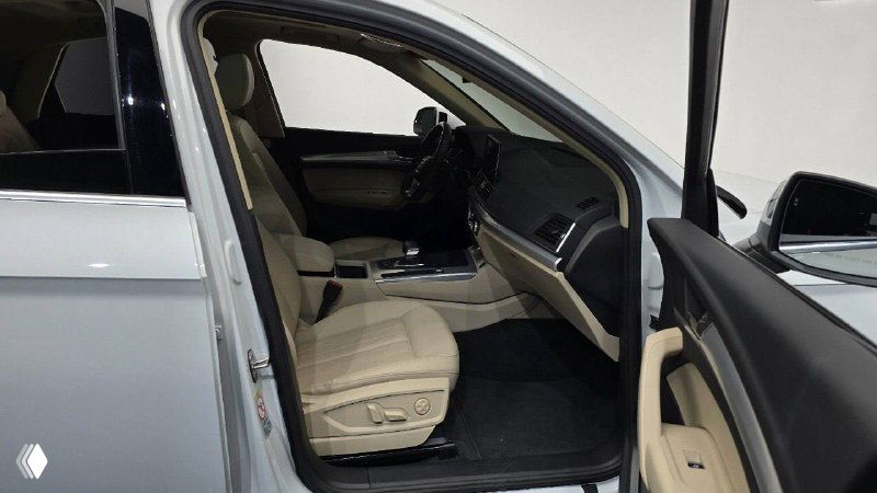 Открытая передняя дверца и вид на водительское сиденье Audi Q5 Sportback — видны пороги, обивка и пространство для ног с близкого расстояния.