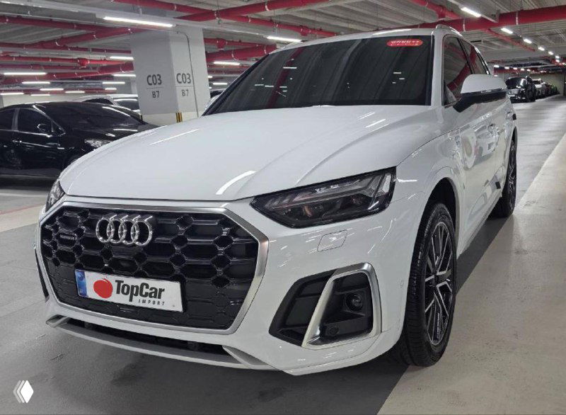 Белый Audi Q5 — передняя часть в подземном паркинге с номерной табличкой TopCar; видно решётку, фары и эмблему Audi.