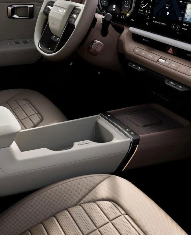 Салон KIA Seltos 2026 крупный кадр центрального тоннеля и передних кресел, отделка материалов и практичные ниши для хранения.